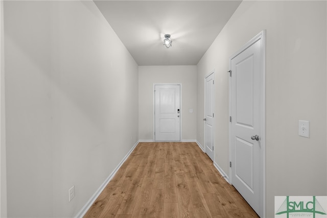 hallway featuring light wood-style floors and baseboards