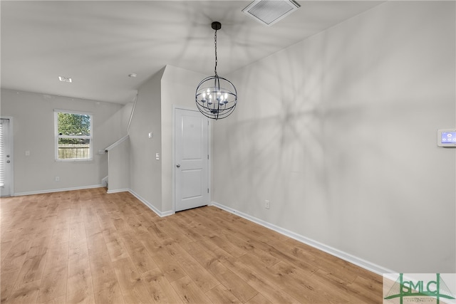 unfurnished dining area with a chandelier, visible vents, light wood-style flooring, and baseboards