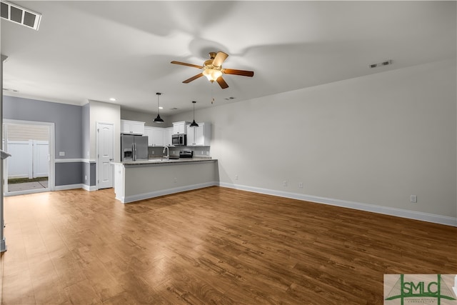 unfurnished living room featuring ceiling fan and hardwood / wood-style floors