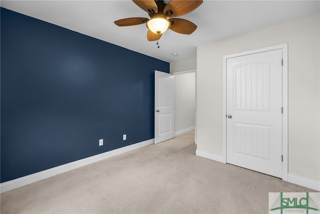 unfurnished bedroom with light carpet, a closet, and ceiling fan