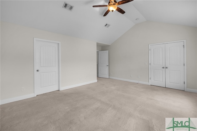 unfurnished bedroom featuring ceiling fan, light colored carpet, and vaulted ceiling