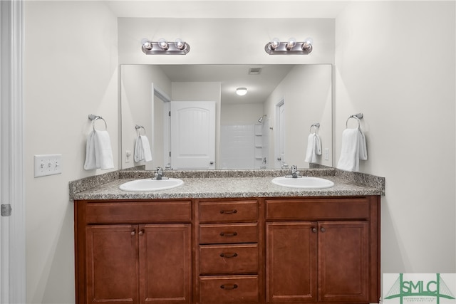 bathroom featuring a shower and vanity