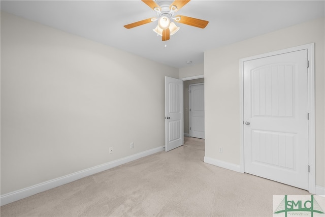 unfurnished bedroom with ceiling fan, light colored carpet, and a closet