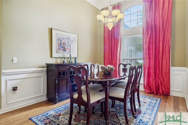 dining space featuring light wood-type flooring and an inviting chandelier