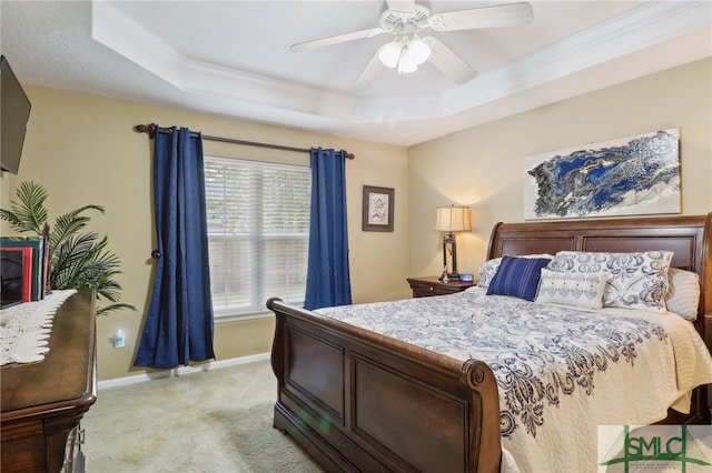 carpeted bedroom featuring a tray ceiling, ceiling fan, and crown molding