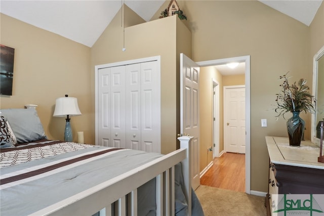 carpeted bedroom with vaulted ceiling and a closet