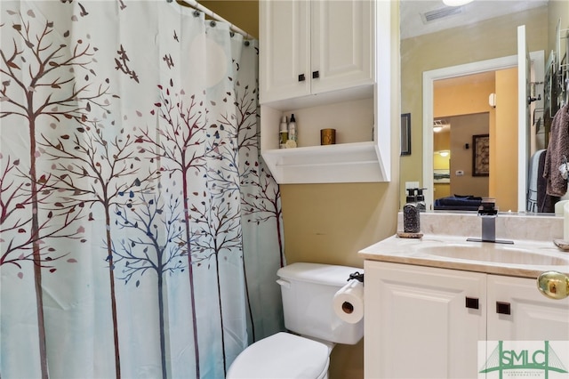 bathroom featuring a shower with shower curtain, vanity, and toilet