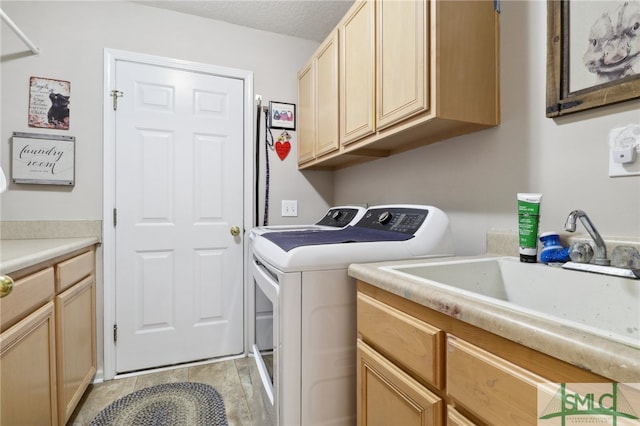 washroom with cabinets, a textured ceiling, and washer and clothes dryer