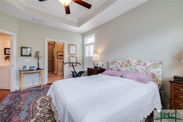 bedroom featuring baseboards, visible vents, ceiling fan, a tray ceiling, and crown molding