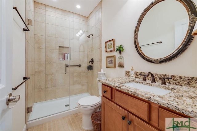 bathroom featuring a shower stall, toilet, and vanity