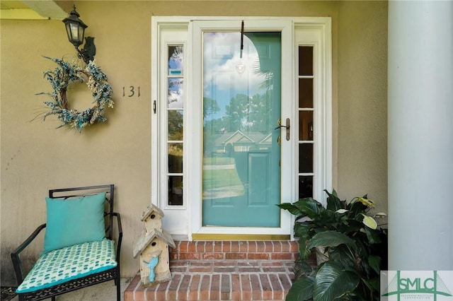 doorway to property featuring stucco siding