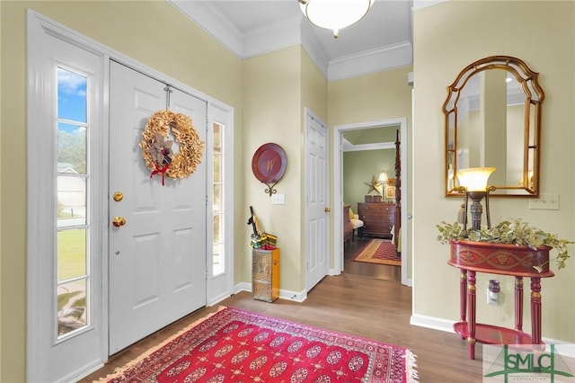 entryway with crown molding, baseboards, and wood finished floors