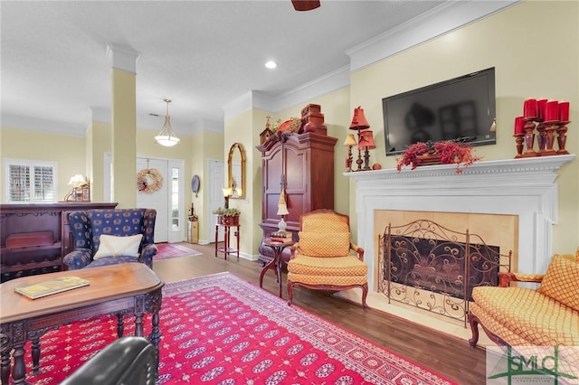 living area with baseboards, a tile fireplace, ornamental molding, wood finished floors, and recessed lighting