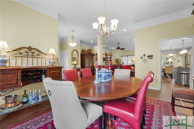 dining space featuring ceiling fan with notable chandelier, dark hardwood / wood-style flooring, and crown molding