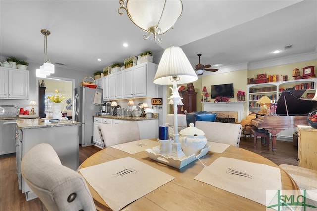 dining room featuring crown molding, hardwood / wood-style flooring, and ceiling fan