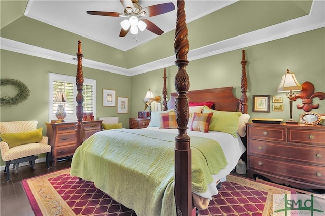 bedroom with a ceiling fan, a tray ceiling, wood finished floors, and ornamental molding