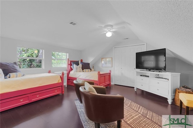 bedroom featuring a ceiling fan, visible vents, vaulted ceiling, and a textured ceiling