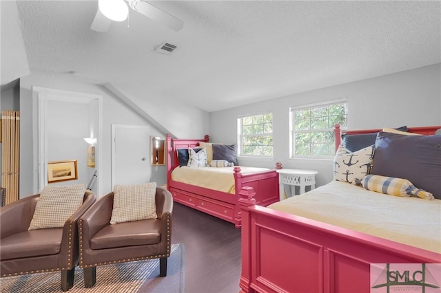 bedroom featuring a ceiling fan, visible vents, vaulted ceiling, and a textured ceiling