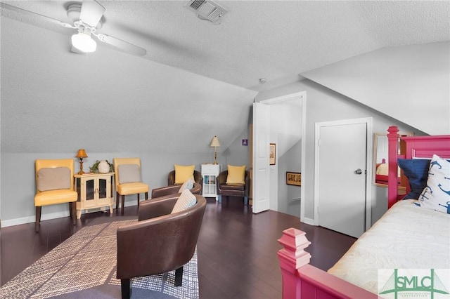 bedroom with lofted ceiling, visible vents, a textured ceiling, wood finished floors, and baseboards