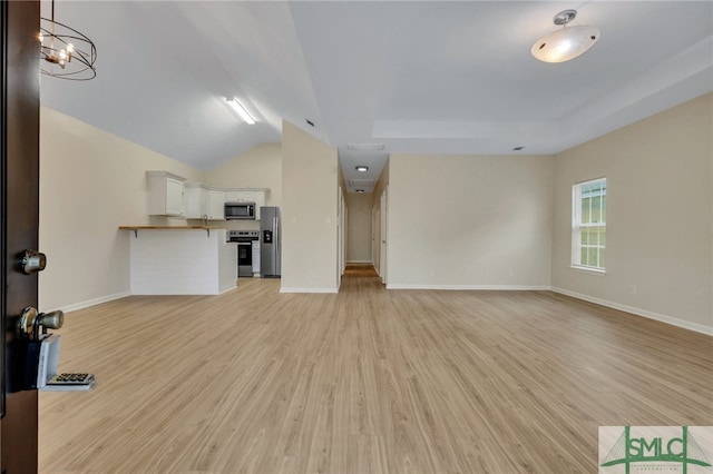 unfurnished living room with light wood-type flooring, lofted ceiling, and a chandelier