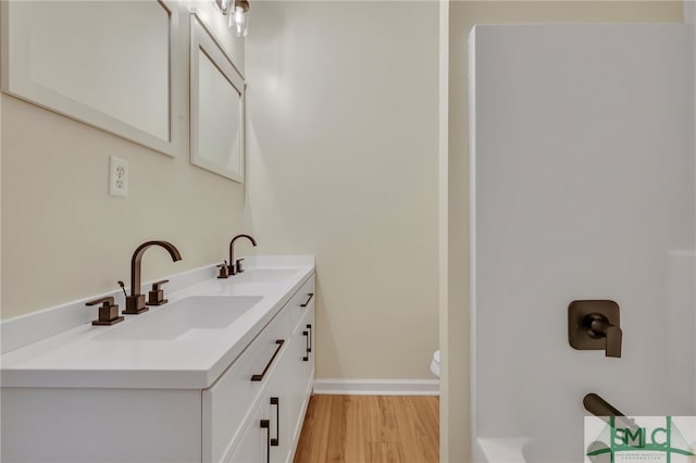 bathroom with vanity, toilet, and wood-type flooring