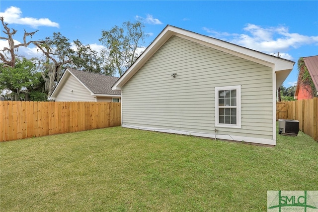 rear view of property featuring a yard and central air condition unit