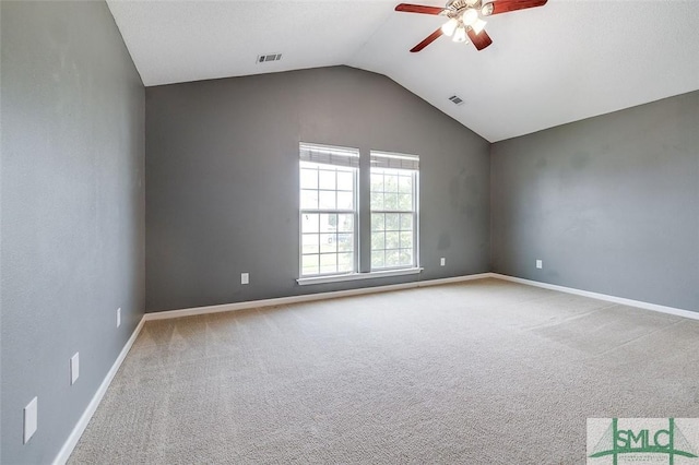 empty room with lofted ceiling, ceiling fan, and carpet flooring