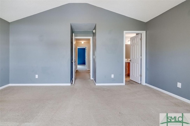 unfurnished room with vaulted ceiling and light carpet