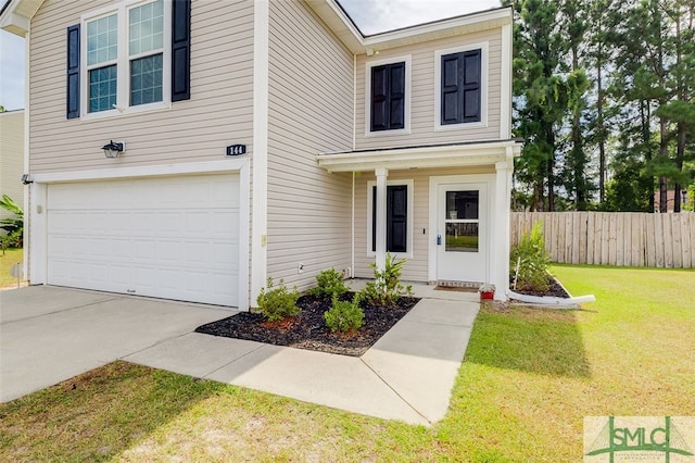 view of front of property featuring a front yard and a garage