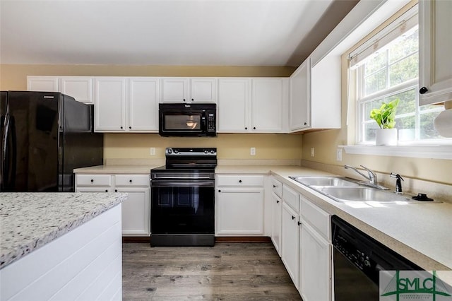 kitchen with black appliances, white cabinets, dark hardwood / wood-style flooring, and sink