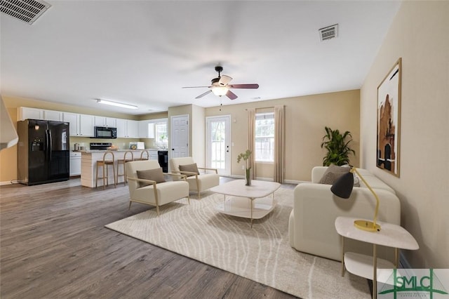 living room with ceiling fan and wood-type flooring