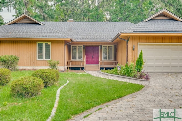 ranch-style house featuring a garage and a front lawn