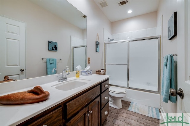 full bathroom with vanity, toilet, and enclosed tub / shower combo