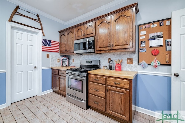 kitchen featuring ornamental molding, appliances with stainless steel finishes, and decorative backsplash