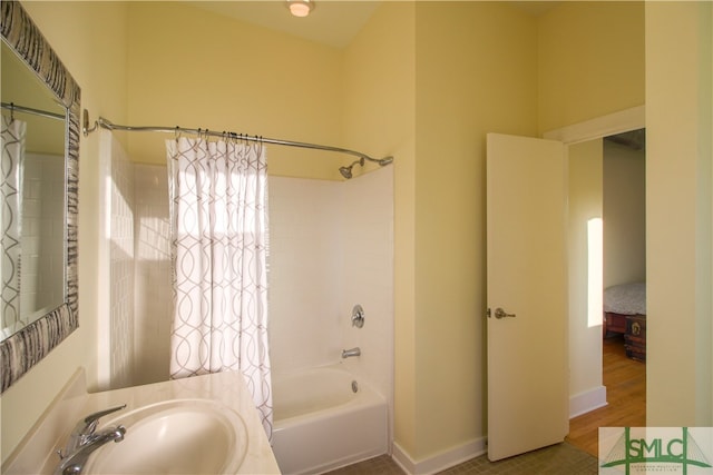 bathroom with hardwood / wood-style floors, sink, and shower / bathtub combination with curtain