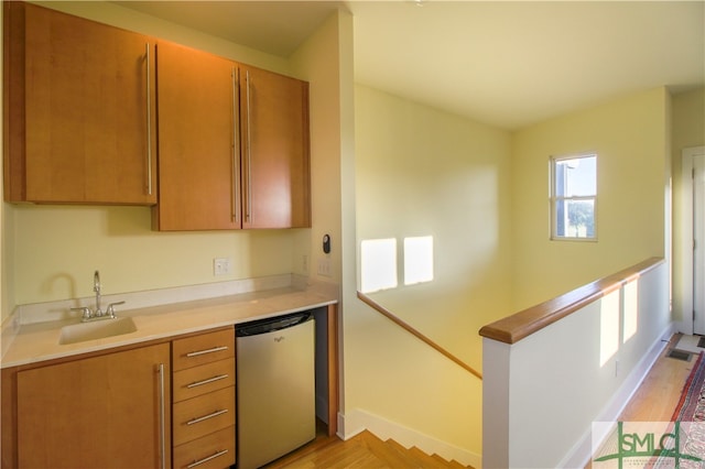 kitchen with sink, light hardwood / wood-style flooring, and dishwasher