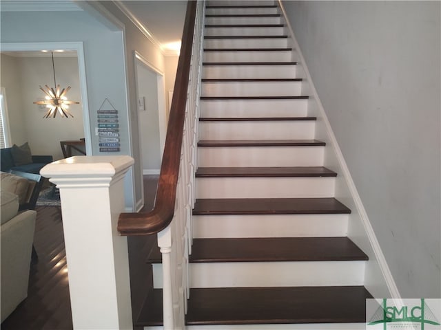 stairs with a chandelier and ornamental molding