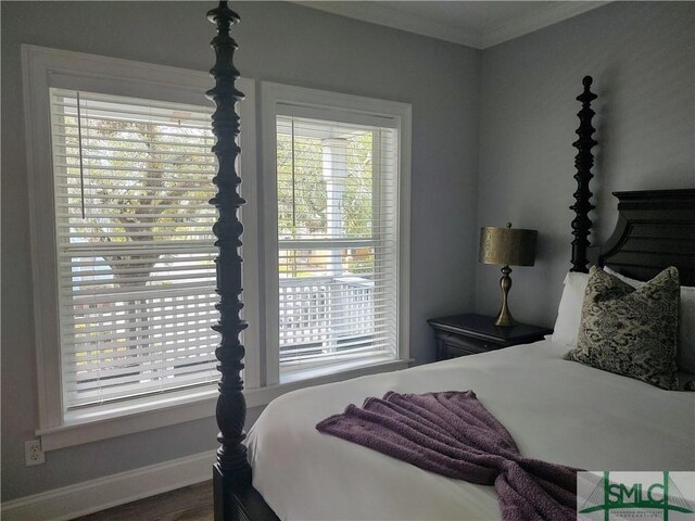 bedroom featuring multiple windows, crown molding, and wood-type flooring