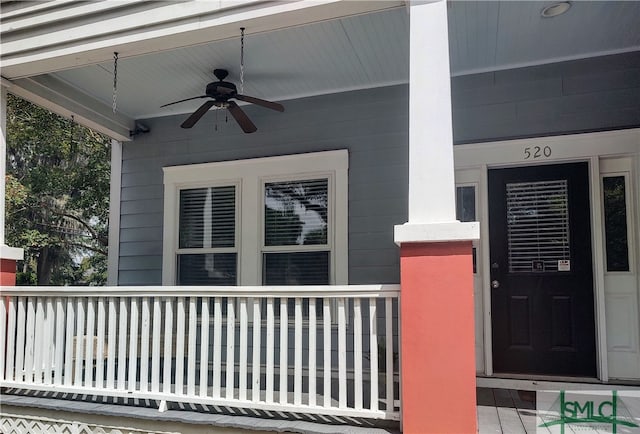 view of exterior entry with a porch and ceiling fan