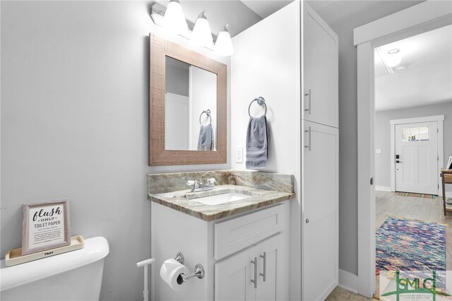 bathroom featuring vanity, toilet, and hardwood / wood-style flooring