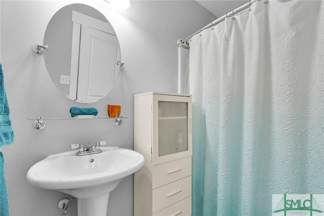 full bath with a sink and curtained shower