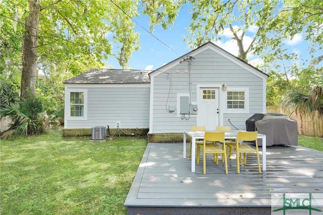 back of property featuring cooling unit, a wooden deck, and a yard