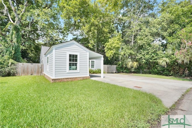 view of front of house featuring driveway, an outdoor structure, and view of wooded area