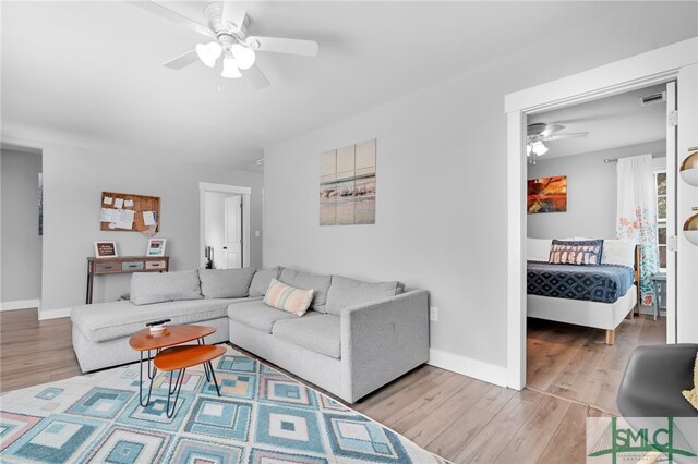 living room featuring ceiling fan and light hardwood / wood-style floors