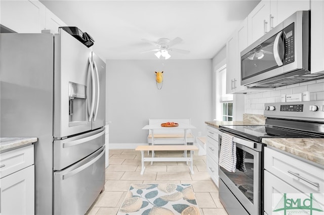 kitchen featuring white cabinetry, stainless steel appliances, light stone counters, ceiling fan, and light tile patterned flooring