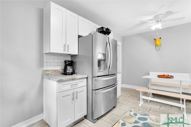 kitchen with white cabinets, stainless steel fridge, backsplash, and ceiling fan