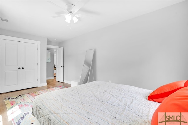 bedroom with light wood-type flooring, a closet, and ceiling fan