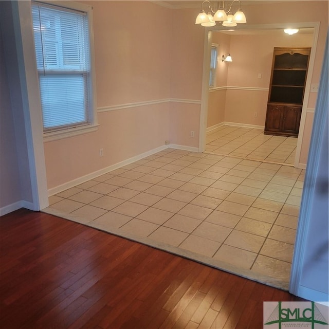 empty room featuring light hardwood / wood-style flooring and a notable chandelier