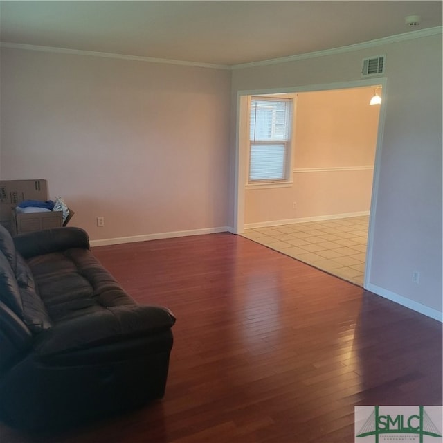 unfurnished living room featuring crown molding and wood-type flooring