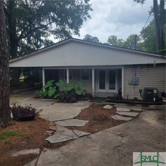 back of property with a porch and central AC